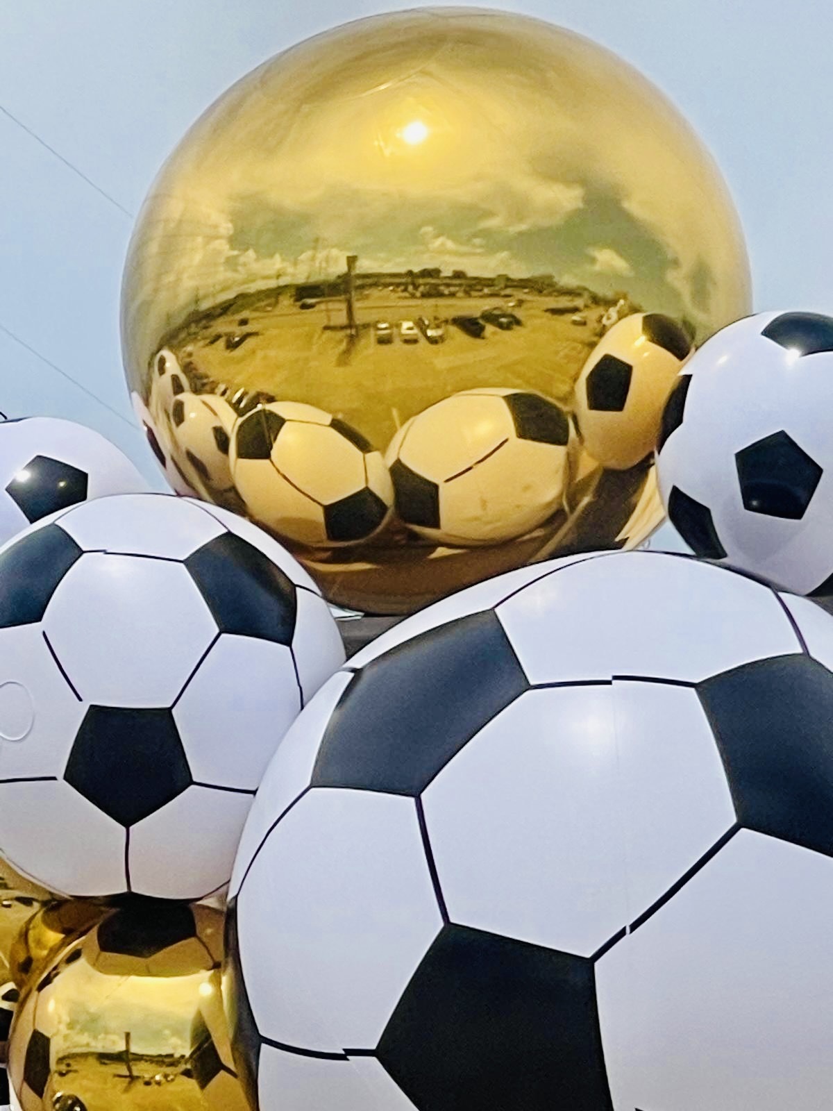 Golden spheres and soccer balls crowning the Karat 22 Jewelers storefront
